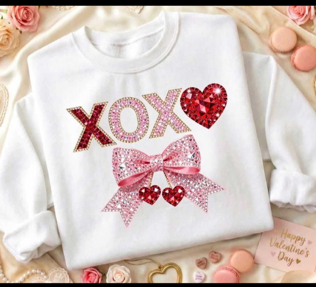 White Valentine sweatshirt with sparkly pink and red XOXO lettering, a rhinestone-style bow, and heart accents in a girly Valentine design.